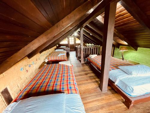sypialnia na poddaszu z 3 łóżkami w pokoju w obiekcie Hostería EL Trapiche Lodge & Spa w Baños