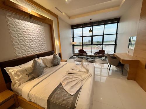a bedroom with a large bed and a table and chairs at Kyriad Prestige Ilkal in Ilkal