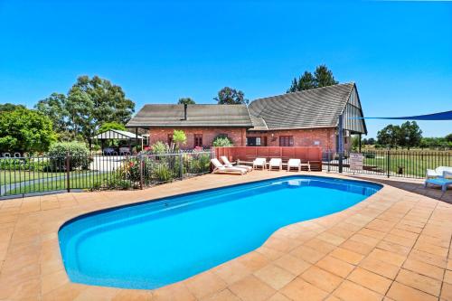 a swimming pool in front of a house at Greenvale Holiday Units Mansfield in Mansfield