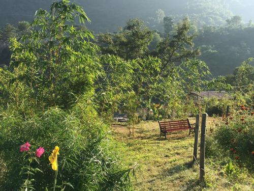 a park bench sitting in a field with flowers at Nayar Valley Retreat in Lansdowne