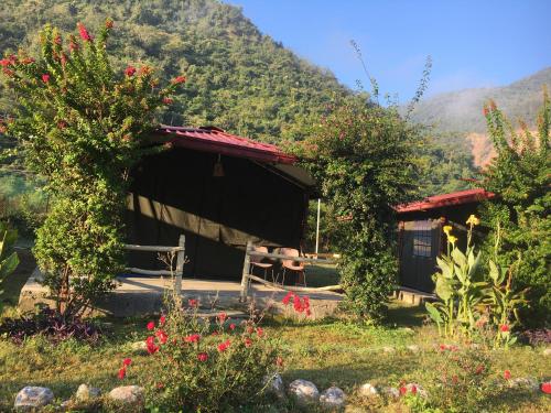 a small cabin with a mountain in the background at Nayar Valley Retreat in Lansdowne