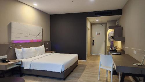 a hotel room with a bed and a desk and a desk at Perdana Hills in Petaling Jaya