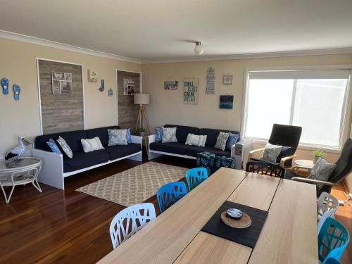 a living room with a couch and a table and chairs at The Beach Shack - OCEAN VIEWS, CLOSE TO THE BEACH in Guilderton