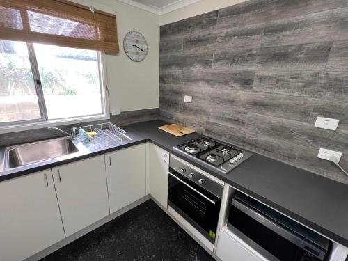 a kitchen with a stove and a sink at The Beach Shack - OCEAN VIEWS, CLOSE TO THE BEACH in Guilderton