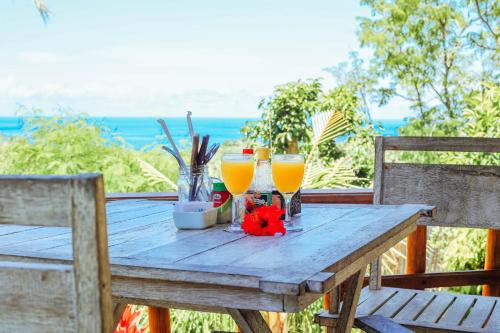 珀尼达岛艾杜森林小屋旅馆的一张木桌,放上两杯橙汁
