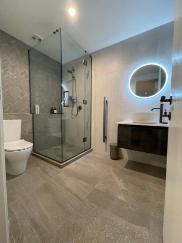 a bathroom with a shower and a toilet and a sink at Luxury at the Lake in Hamilton