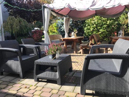 a patio with chairs and tables and an umbrella at Arkadia Gościniec-klima,parking,ogród in Opole