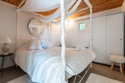 a bedroom with a white canopy bed with a mirror at RENAISSANCE in Arachova