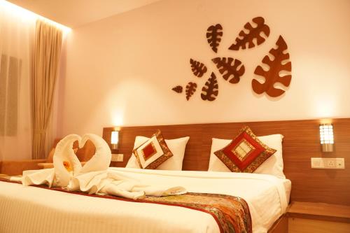 two beds in a hotel room with swans on the wall at Hotel Gorbandh in Udaipur