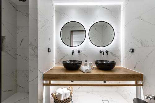 a bathroom with two sinks and two mirrors at Hotel Palatia in Naxos Chora