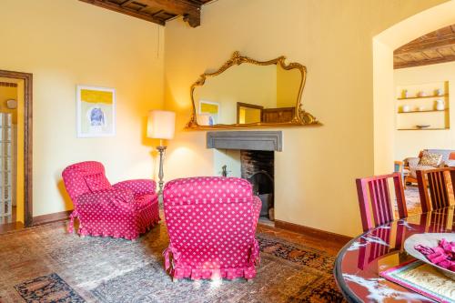 a living room with two pink chairs and a mirror at Villa Rita in Vicopisano