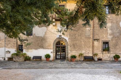 a building with a door and benches in front of it at Villa Rita in Vicopisano