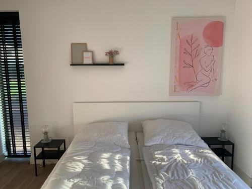 1 dormitorio con 1 cama y una foto en la pared en Modern villa in Harderwold with garden, en Zeewolde