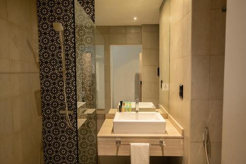 ein Bad mit einem Waschbecken und einem Spiegel in der Unterkunft Kingsgate Al Jaddaf Hotel by Millennium in Dubai