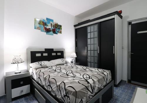 a bedroom with a bed and a black door at Cozy apartment with a private garden in Giza in Sheikh Zayed