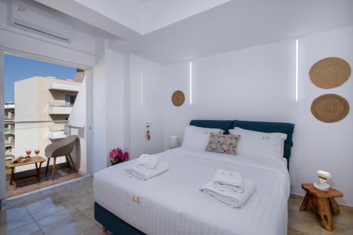 een slaapkamer met een groot wit bed en een balkon bij Lucky Suites in Rethimnon