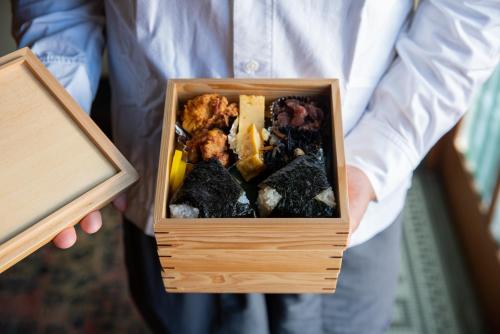 a man is holding a wooden box of rocks at Bamba Hotel Tokyo-Private Townhouse- in Tokyo