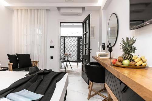 a room with a bed and a table with a bowl of fruit at Hotel Palatia in Naxos Chora
