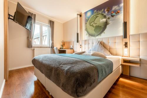 a bedroom with a large bed and a television at Hotel auszeit Neunkirchen-Seelscheid in Neunkirchen