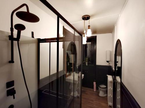 uma casa de banho com uma cabina de duche em vidro e um WC. em Chambres d'hôtes La Maison Blanche em Saint-Junien