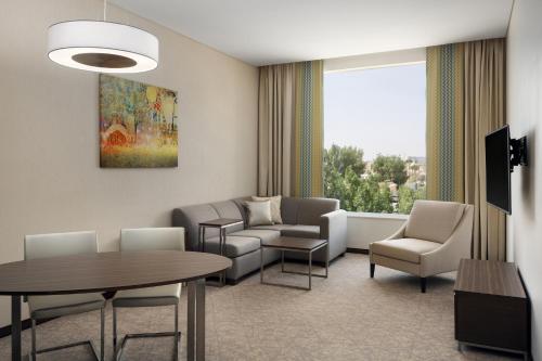 a waiting room with a table and chairs and a window at Hyatt Place Riyadh Sulaimania in Riyadh