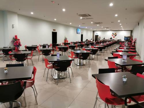 a room filled with tables and chairs with red chairs at LI HUA HOTEL , BINTULU SENTRAL in Bintulu