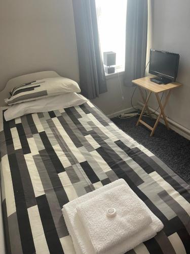 1 dormitorio con 1 cama y escritorio con ordenador portátil en Shakers Inn en Harwich