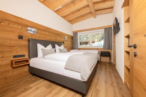 a bedroom with a large bed in a room with wooden walls at Apartments am Bichl in Fulpmes