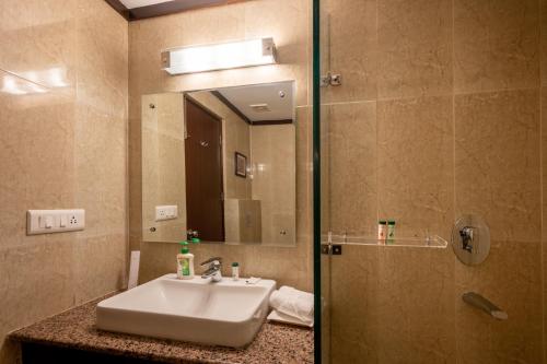 a bathroom with a sink and a mirror at Revathi Resorts in Jajal