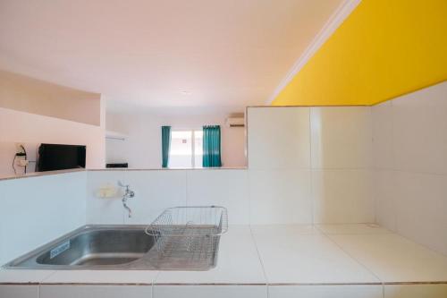 BalianにあるRedDoorz at Kawaii Apartment Jimbaranの黄色の天井のキッチン(シンク付)