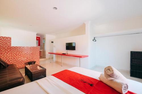 a bedroom with a bed and a desk in a room at RedDoorz at Kawaii Apartment Jimbaran in Balian