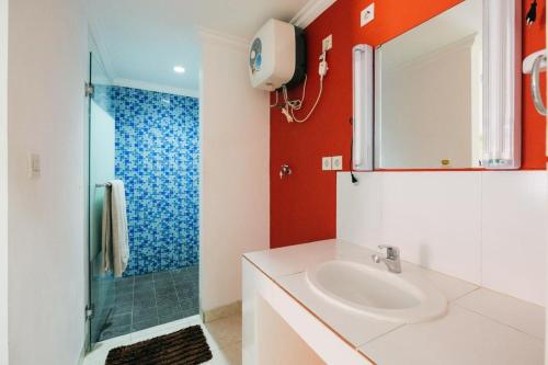 a bathroom with a sink and a shower at RedDoorz at Kawaii Apartment Jimbaran in Balian