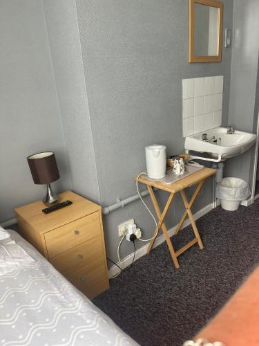 - une chambre avec un lit, un lavabo et une table dans l'établissement Shakers Inn, à Harwich