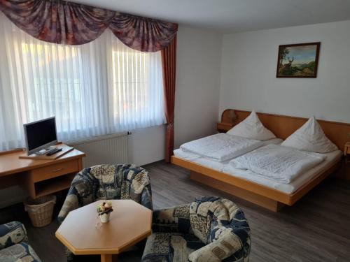 une chambre d'hôtel avec un lit, deux chaises et une table dans l'établissement Pension Jung, Bäckerei-Konditorei & Café, à Ruhla