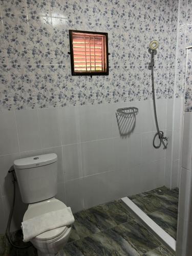 a bathroom with a toilet and a window at Traditional Thai house บ้านเรือนไทย ใกล้หาดระยอง in Ban Chak Phai