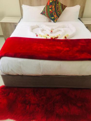 a bed with a red and white blanket on it at Classy Guest House in Johannesburg