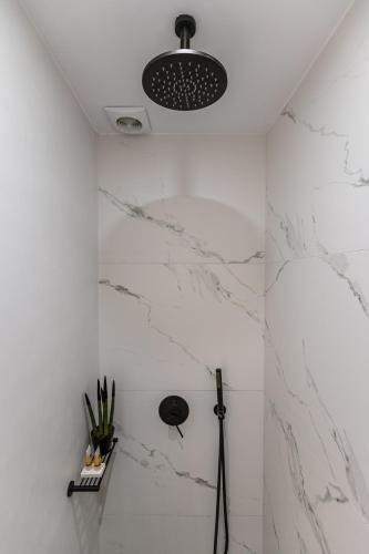 a bathroom with white marble walls and a light fixture at Hotel Palatia in Naxos Chora