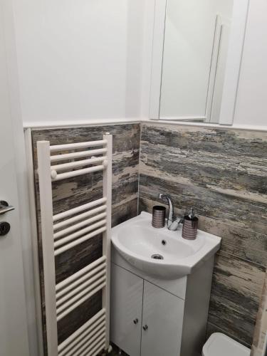 a bathroom with a white sink and a toilet at Bella House Apartaments in Craiova