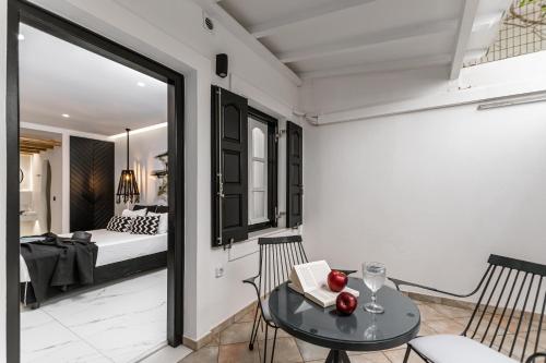 a room with a table and chairs and a bedroom at Hotel Palatia in Naxos Chora