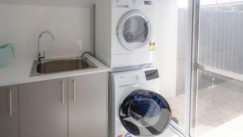 a washing machine in a kitchen next to a sink at Serenity by the Sea in Busselton