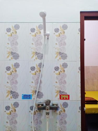 a shower with a hose attached to a wall at Homestay Premium 45 in Jepara