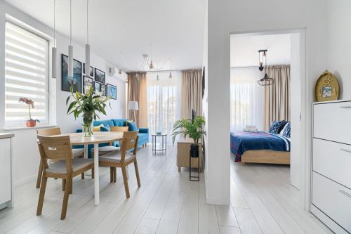 kuchnia i jadalnia ze stołem oraz sypialnia w obiekcie Mi Casa Holidays Apartamenty Olimpijska O2 w mieście Mielno
