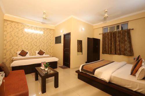 a hotel room with two beds and a couch at Hotel Nexus in Lucknow