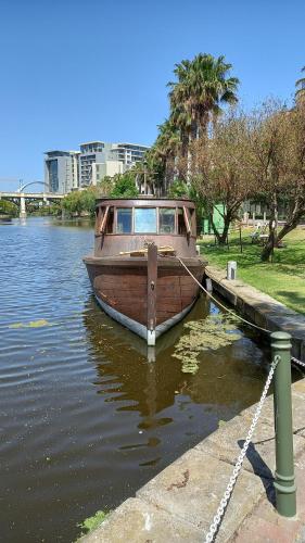 um barco amarrado a uma doca na água em ALTAIR . Wooden Boat . Cape Town na Cidade do Cabo