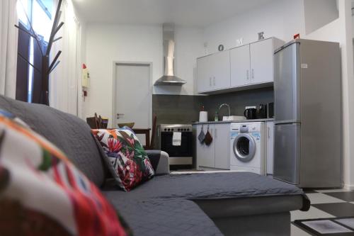 a living room with a couch and a washing machine at Santa Luzia Center in Ribeira Grande