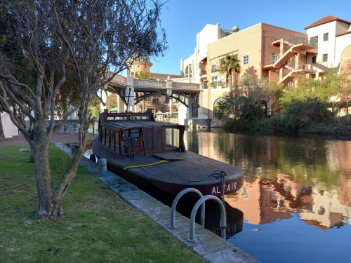 a boat parked on the side of a river at ALTAIR . Wooden Boat . Cape Town in Cape Town