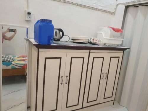 a kitchen cabinet with a blue container on top of it at Anikas vacation home in Coron