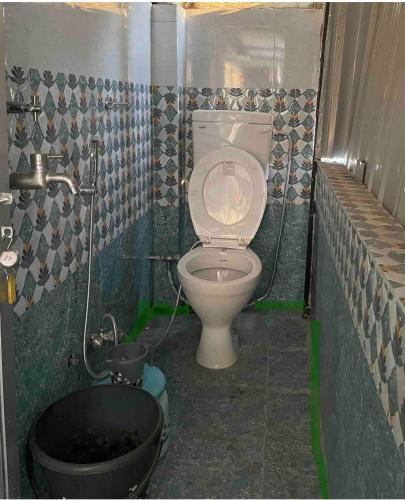 a small bathroom with a toilet and a tub at Wanderlust Hostel & Home Stay in Varanasi