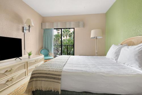 1 dormitorio con 1 cama grande y TV en Sandcastle Oceanfront Resort at the Pavilion, en Myrtle Beach