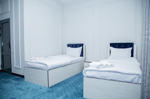 two beds sitting next to each other in a room at Lola Kokand Hotel in Kokand